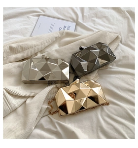 Three geometric faceted evening clutch bags in gold, silver, and dark grey metallic finish