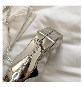 Detail of silver mirror metal clutch with unique crumpled geometric folding texture
