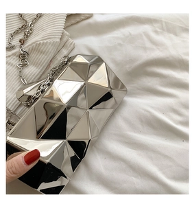 Macro view of silver geometric acrylic clutch with a metallic chain and faceted design