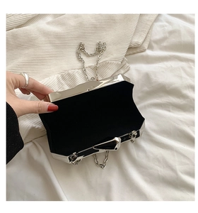 Detail view of silver acrylic clutch with black velvet lining and metallic chain strap