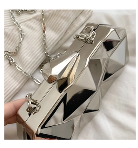 Detailed view of silver mirror geometric clutch bag with metallic facets and chain
