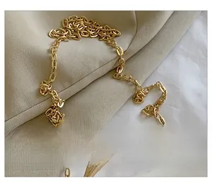 Detailed macro shot of a golden leopard metal buckle and polished chain strap