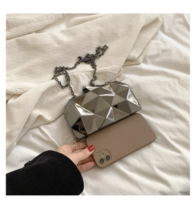Detailed size comparison of silver geometric evening clutch with metallic chain and phone