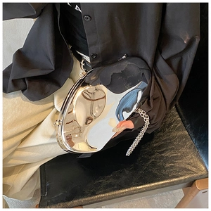 Close-up of a silver mirror acrylic evening clutch bag with fluid irregular geometry and chain