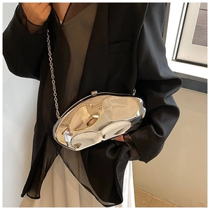 Silver liquid metal acrylic clutch bag with thin chain strap shown on black outfit