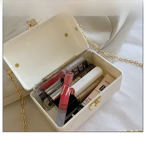 Detail view of white acrylic box bag showing interior capacity with golden chain and clasp