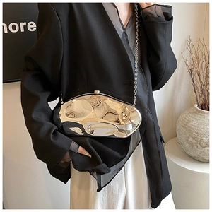 Detail of silver mirror acrylic clutch featuring a liquid metal design and fine chain