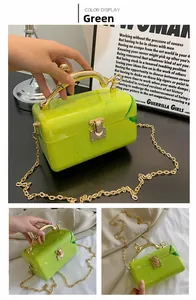 Detail of green marble acrylic clutch bag featuring vintage carved gold handle and chain