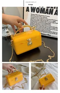 Detail of orange marble acrylic box clutch with golden antler handle and chain strap