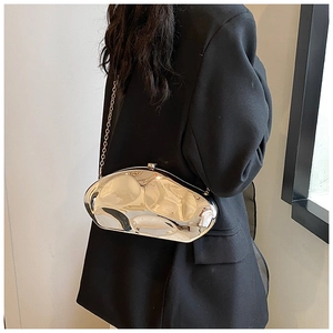 Close-up of a silver irregular geometric chain bag with liquid metal texture on a blazer