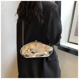 Close-up of a metallic silver oval clutch bag featuring a high-gloss mirror finish and chain