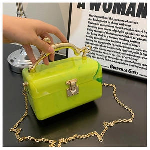 Macro shot of green marble acrylic clutch with leopard-shaped gold handle and chain