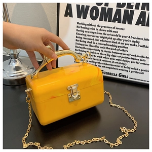 Detail of yellow acrylic marble box bag with vintage gold handle and metallic chain strap
