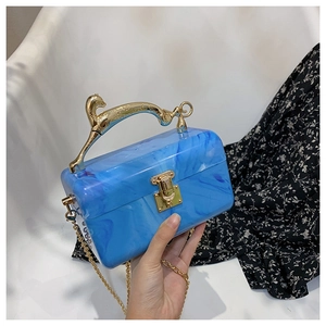 Detail of blue marble acrylic clutch with gold leopard handle and elegant chain strap