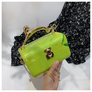 Detail of neon green marble acrylic clutch with a golden leopard handle and chain strap