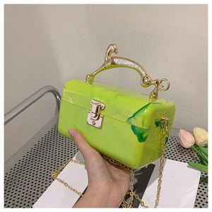 Macro shot of green marble acrylic clutch featuring a golden horse-shaped handle