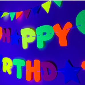 Striscione Neon Happy Birthday e decorazioni stellari fluorescenti brillanti sotto luce nera