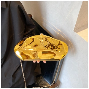 Detail of gold acrylic evening clutch with fluid liquid metal texture and chain strap