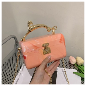 Detail of candy color marble acrylic clutch with golden panther handle and metal chain