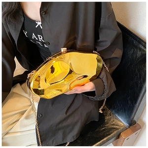 Detail of artistic gold irregular acrylic handbag with glossy mirror finish and chain strap