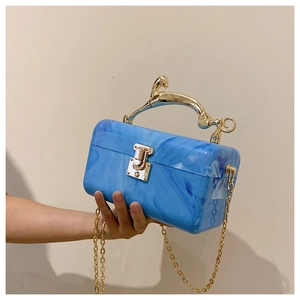 Detail of blue marble acrylic box clutch featuring a gold leopard handle and chain