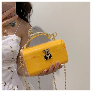 Detail of acrylic marble evening bag with leopard metal handle and gold chain strap
