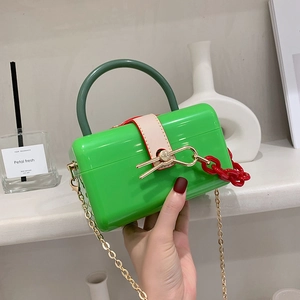 Neon green acrylic box bag with gold bow clasp and decorative double chain straps