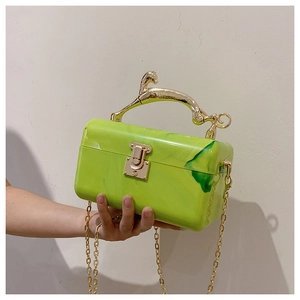 Detailed macro view of green marble acrylic bag with a decorative gold horse handle