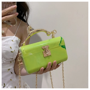 Detail of green marble acrylic clutch bag featuring a gold leopard-shaped metal handle