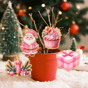 Close-up of four pink wooden Christmas ornaments hanging on a tree with soft bokeh lights