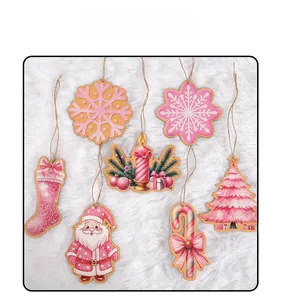 Detailed view of pink hand-painted wooden Christmas ornaments with snowflake and Santa shapes