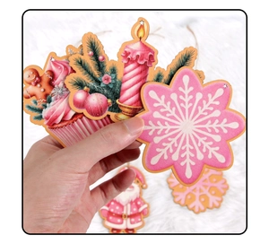 Close-up of pink wooden Christmas charms featuring Santa and gingerbread held by hand