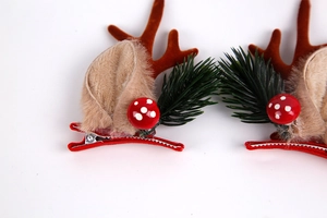 Close-up of Christmas cat hair clips with reindeer antlers and red mushroom decor