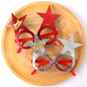 Close-up of red and silver star-shaped Christmas glasses with Merry Christmas text on a wooden tray