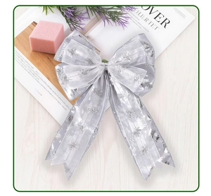 Detail of silver mesh Christmas bow with glittery trees and Merry Christmas text