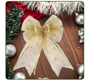 Macro view of white mesh Christmas bow with gold glitter ribbons on wood background