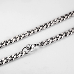 Detailed macro view of polished silver cuban link chain with lobster clasp closure