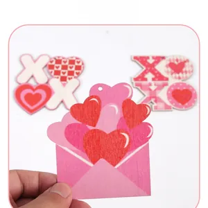 Detail of wooden Valentine's heart ornament featuring XOXO design and pink envelope pattern
