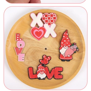 Detail of wooden Valentine ornaments featuring gnome designs and LOVE text on a tray