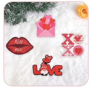 Close-up of Valentine's wooden ornaments with Kiss me and LOVE text on white plush background