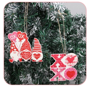 Detail of wooden Valentine's Day gnome and XOXO hanging ornaments on a Christmas tree