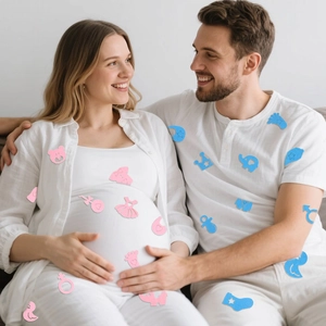 Detail of baby gender reveal felt stickers featuring pink and blue cartoon shapes on clothing