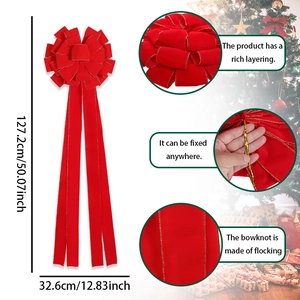 Detailsicht der großen roten Weihnachtsschleife mit Goldrand und langen Bändern