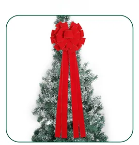 Detail einer roten Samt-Weihnachtsschleife mit Goldrand auf verschneitem Zweig