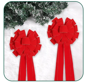 Detail von roten Weihnachtsschleifen aus Samt mit Goldrand auf weißem Webpelz