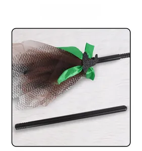 Detail of Halloween witch broom with green satin bow and glittering wizard hat accent