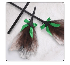 Detail of Halloween witch broom with green bow, mesh fabric, and glittery mini hat