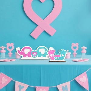 Detail of baby gender reveal wooden table signs featuring blue and pink elephants