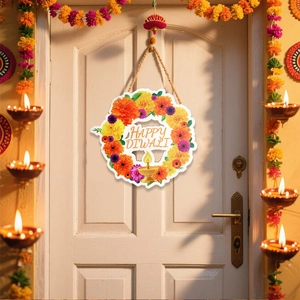Happy Diwali floral wreath hanging on a white door with marigold garlands and oil lamps