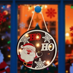 Detail of round wooden Christmas door sign with LED lights and cartoon Santa Claus figure